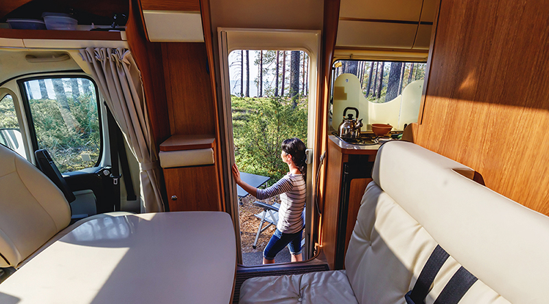 Interior view of a camper motorhome with person standing in the entrance looking out at the view after an rv inspections