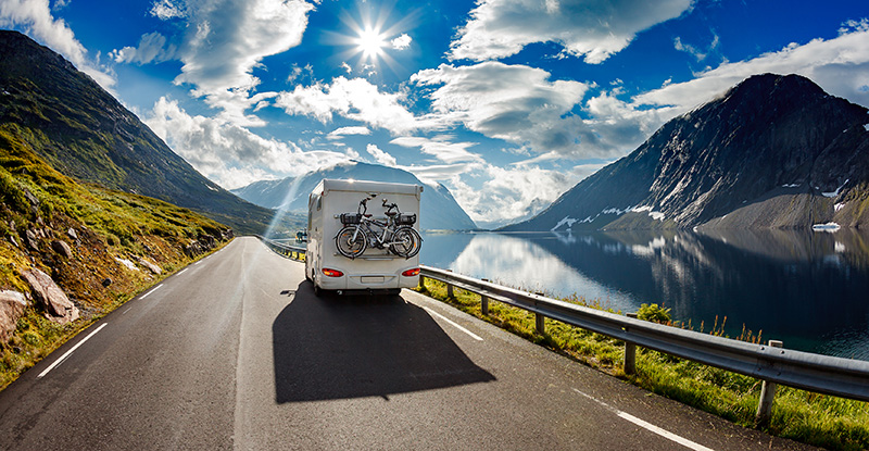 Camper van driving on a mountain highway after thorough rv inspection services 